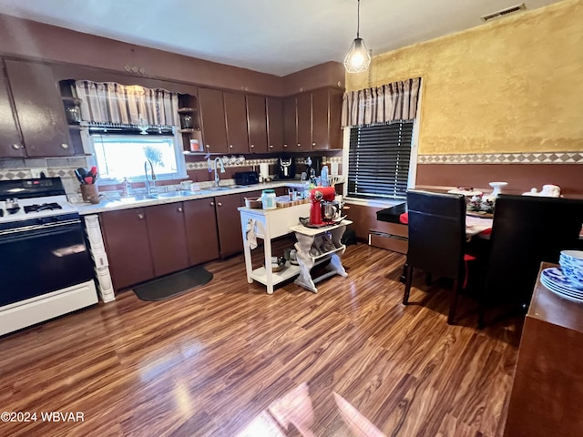 kitchen with sink, pendant lighting, range, and dark brown cabinetry