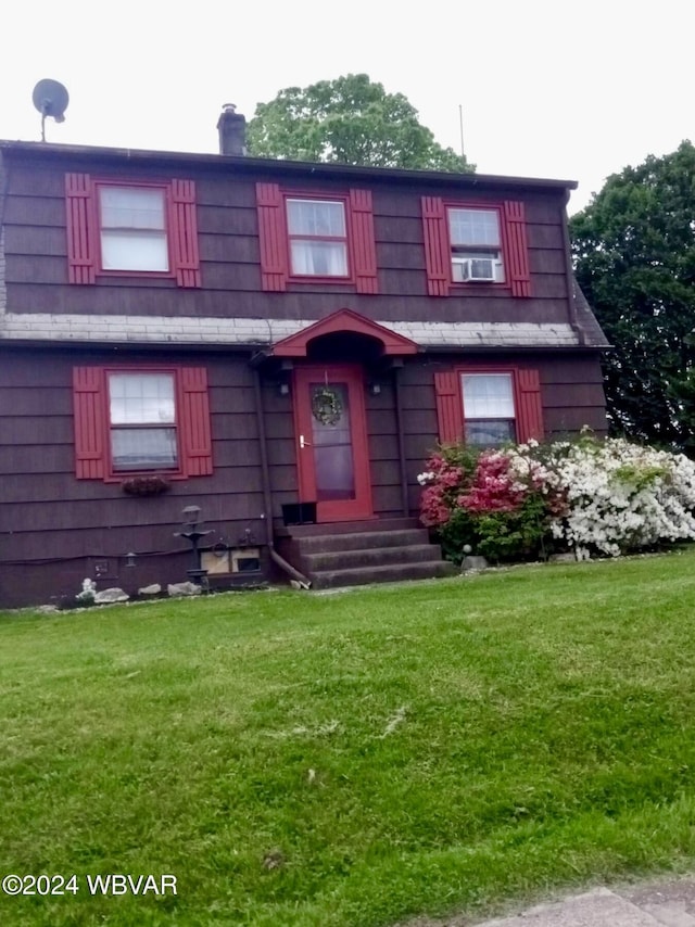 view of front facade with cooling unit and a front lawn