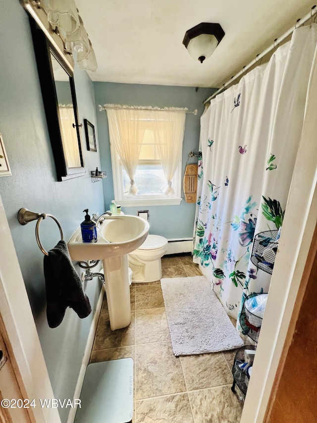 bathroom with baseboard heating, toilet, and tile patterned flooring