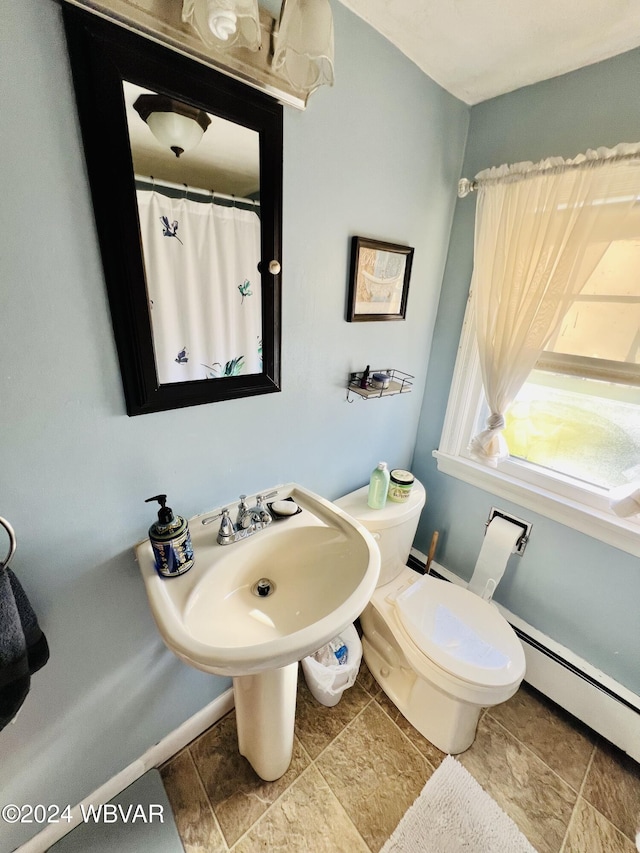 bathroom featuring baseboard heating and toilet