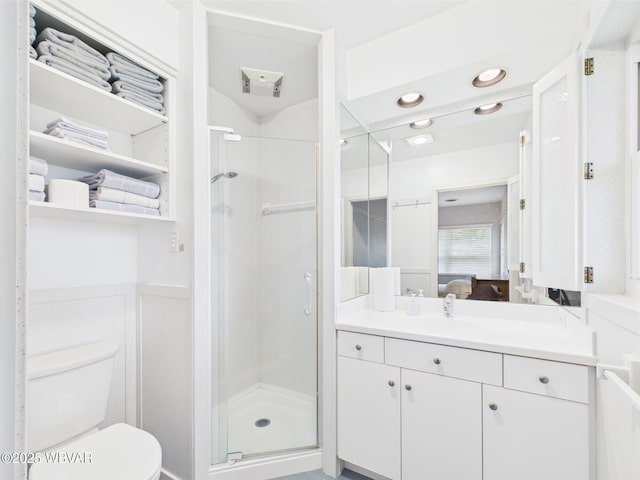 ensuite bathroom featuring a stall shower, vanity, toilet, and recessed lighting