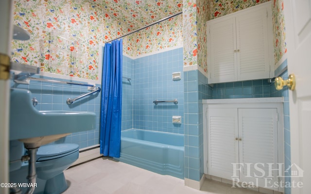 full bath featuring a wainscoted wall, shower / tub combo with curtain, and wallpapered walls