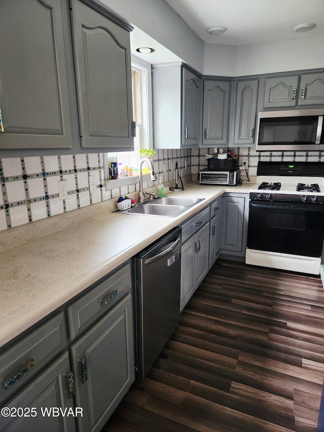 59 Keyser Cir, Williamsport, PA 17701 - kitchen featuring appliances with stainless steel finishes, gray cabinetry, backsplash, dark wood-style flooring, and light countertops