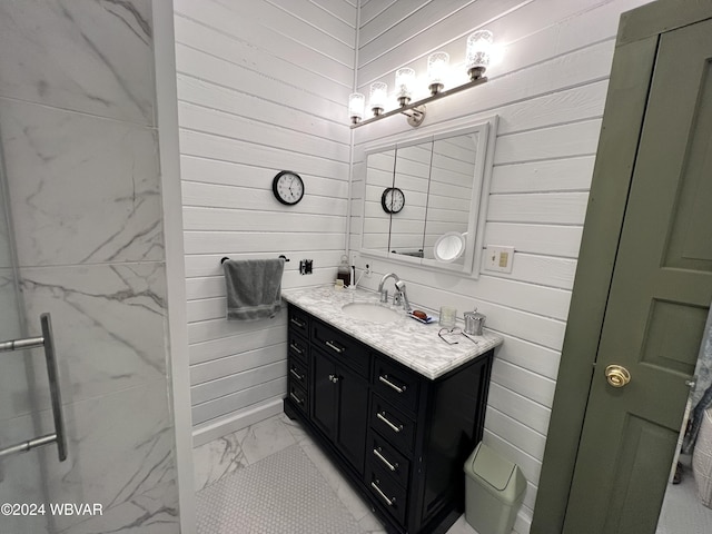 bathroom with vanity, a shower with door, and wooden walls