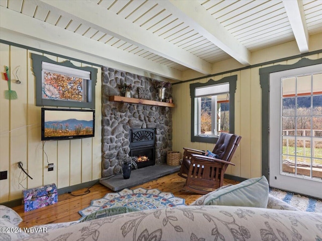 living room with beam ceiling, a fireplace, and hardwood / wood-style flooring