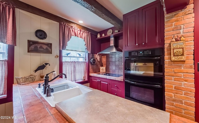 kitchen with beam ceiling, sink, wall chimney exhaust hood, and black appliances