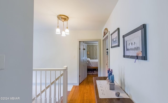 hall with an inviting chandelier and light wood-type flooring