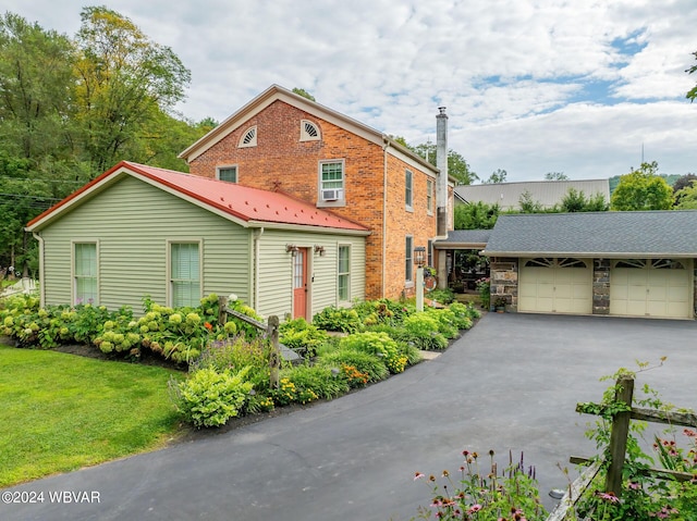 view of front of home with a garage and an outbuilding