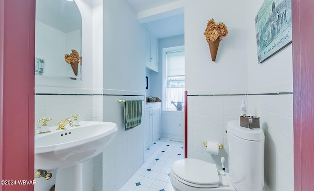 bathroom featuring tile patterned floors, tile walls, and toilet