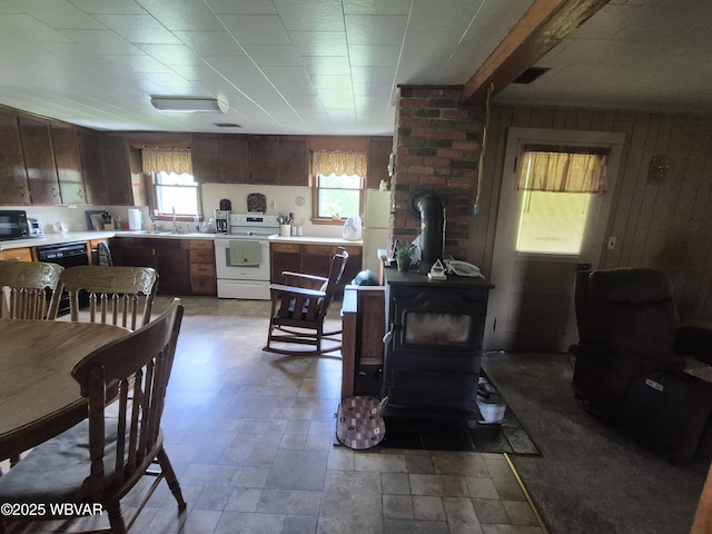 3510 Rt 184, Trout Run, PA 17771 - kitchen with white electric stove, a wood stove, light countertops, stone finish flooring, and wood walls