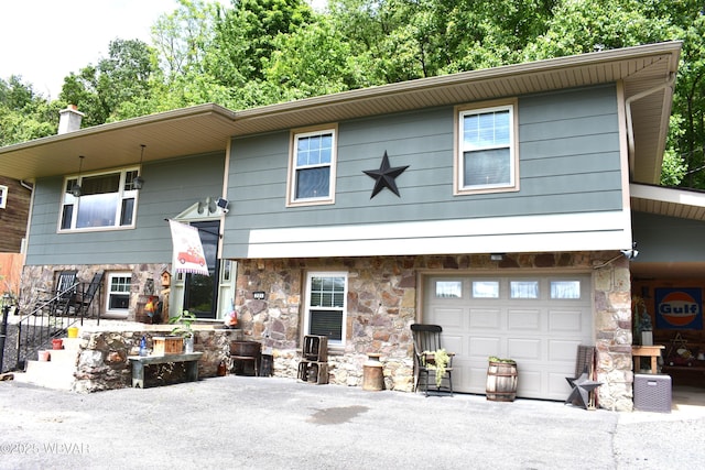 201 Richey St, Lock Haven, PA 17745 - raised ranch with stone siding, an attached garage, and a chimney