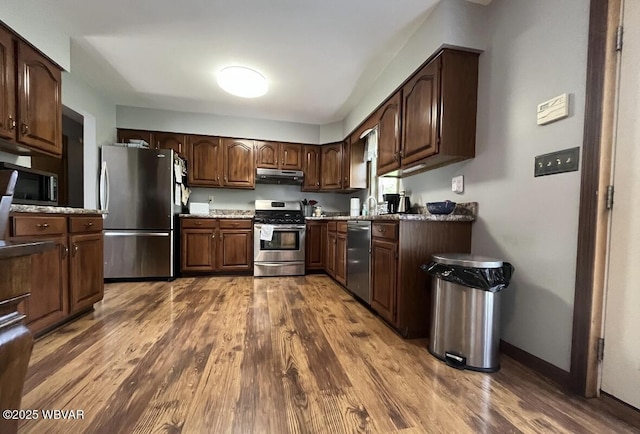 150 Pine Creek Ave, Jersey Shore, PA 17740 - kitchen with appliances with stainless steel finishes, under cabinet range hood, dark wood-type flooring, and dark brown cabinets
