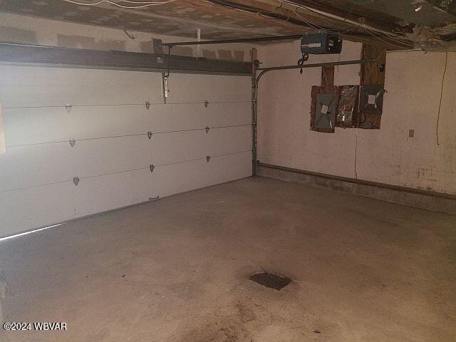 garage with electric panel and a garage door opener