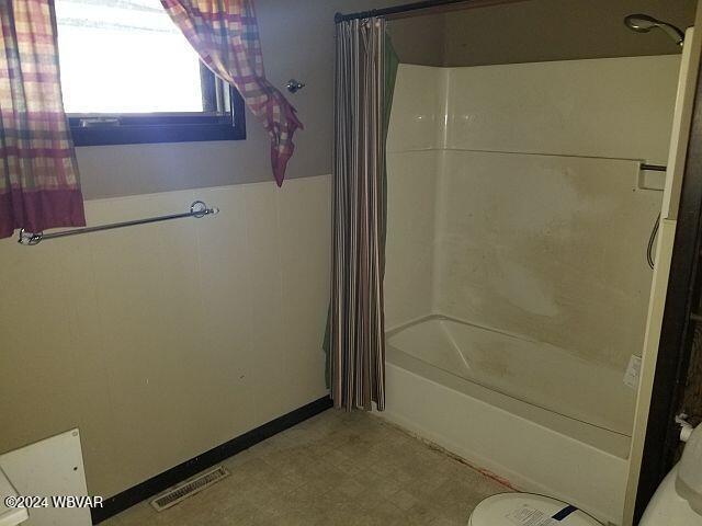 bathroom featuring shower / bathtub combination with curtain