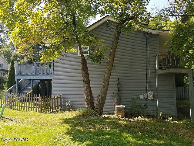 view of home's exterior featuring central AC unit, a deck, and a yard