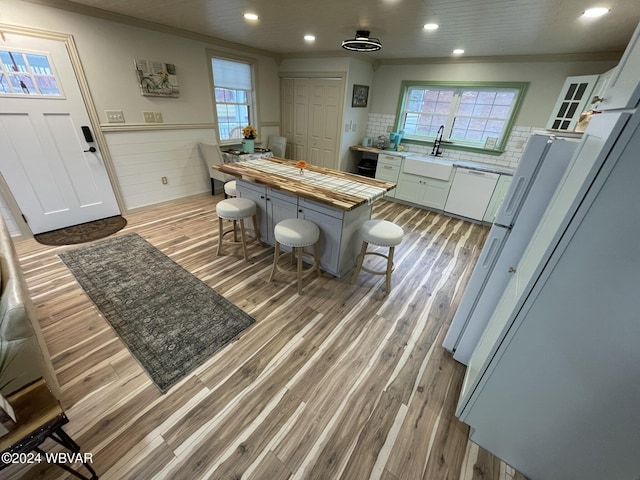 kitchen featuring light wood-type flooring, a wealth of natural light, and ornamental molding