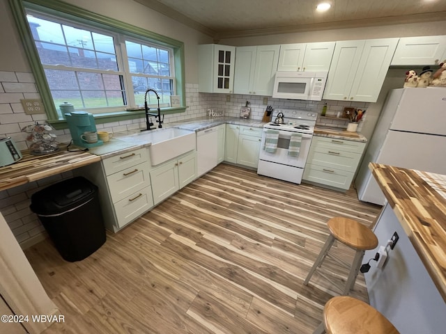 kitchen with sink, wood counters, light hardwood / wood-style flooring, white appliances, and white cabinets