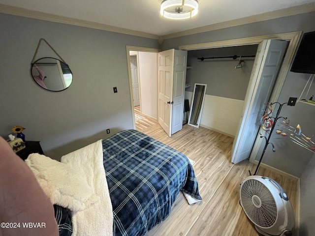 bedroom featuring crown molding, a closet, and light hardwood / wood-style floors