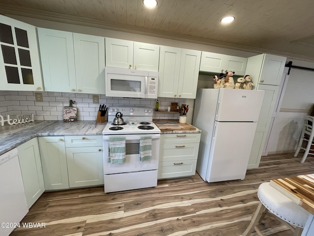 kitchen with light wood-type flooring, backsplash, white appliances, a barn door, and white cabinets