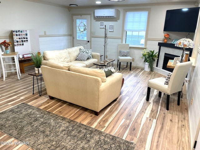 living room with plenty of natural light, a wall unit AC, and light hardwood / wood-style flooring