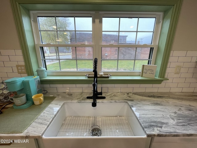 room details featuring light stone countertops and sink