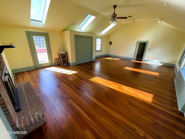 additional living space featuring dark hardwood / wood-style flooring, ceiling fan, and vaulted ceiling with skylight