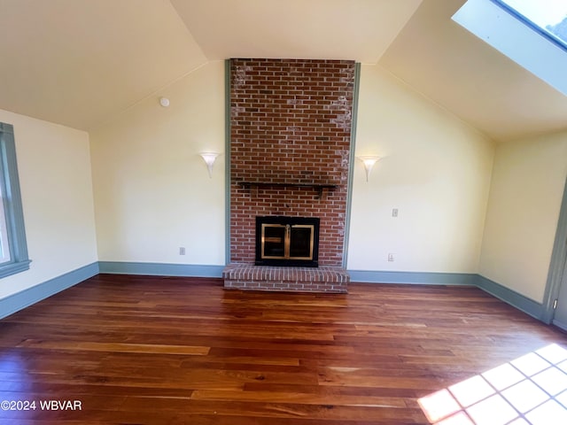 unfurnished living room with wood-type flooring, a fireplace, and lofted ceiling with skylight