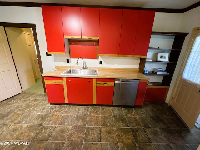 kitchen featuring butcher block countertops, stainless steel dishwasher, crown molding, and sink