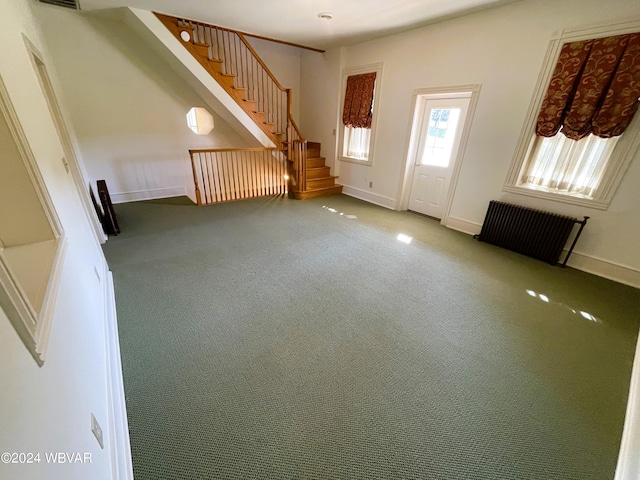 carpeted entrance foyer featuring radiator heating unit