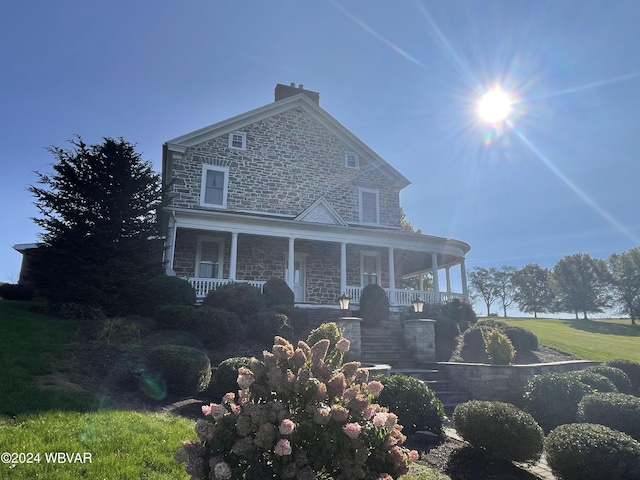 view of front of home with a porch and a front lawn