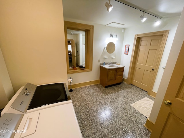 bathroom with vanity, washer / clothes dryer, and rail lighting