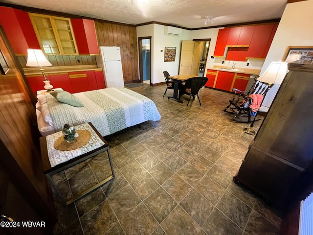 bedroom with an AC wall unit, sink, ornamental molding, a textured ceiling, and white fridge