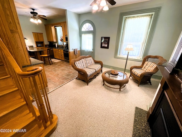 living area featuring light carpet, ceiling fan, and sink