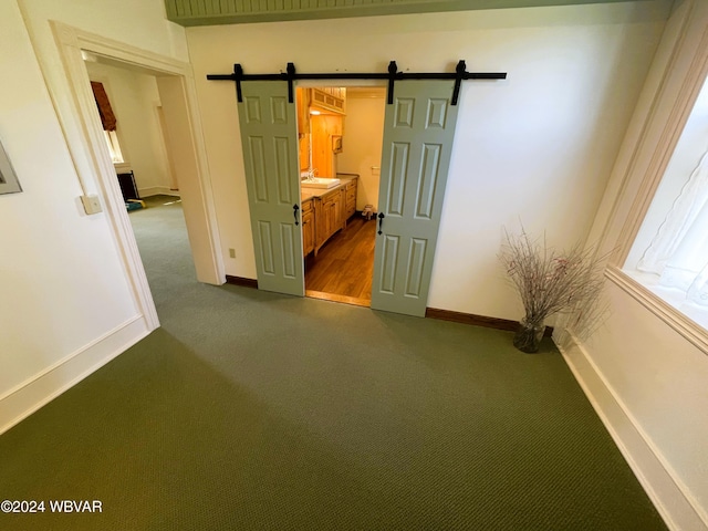 carpeted spare room with a barn door and sink