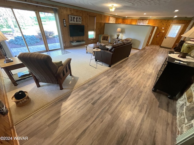 living room featuring wooden walls, plenty of natural light, and light wood-type flooring