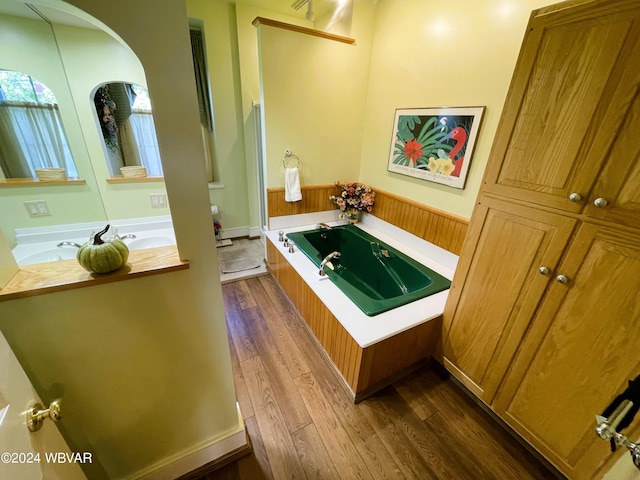 bathroom featuring hardwood / wood-style floors, vanity, and a tub to relax in