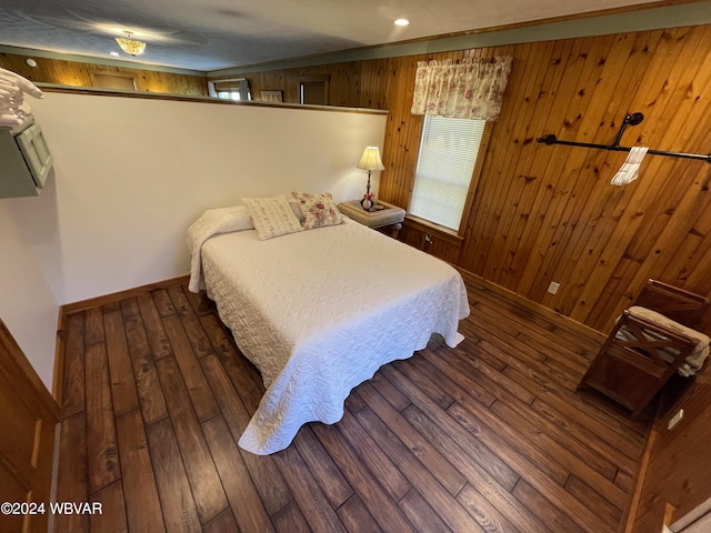 bedroom with wooden walls and dark wood-type flooring