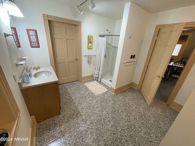 bathroom featuring vanity, track lighting, and walk in shower