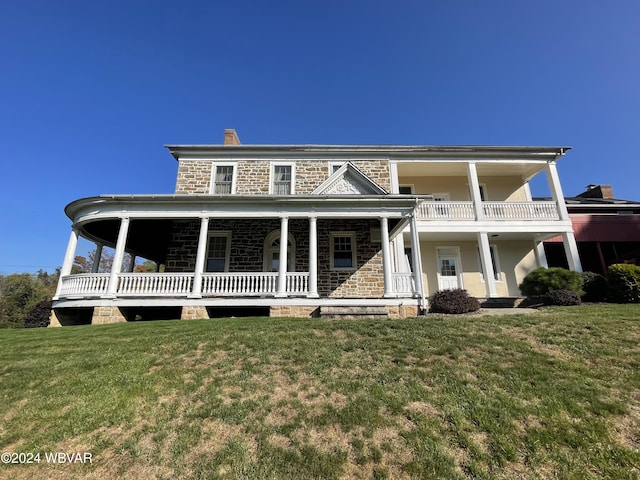 view of front of home with a balcony and a front yard