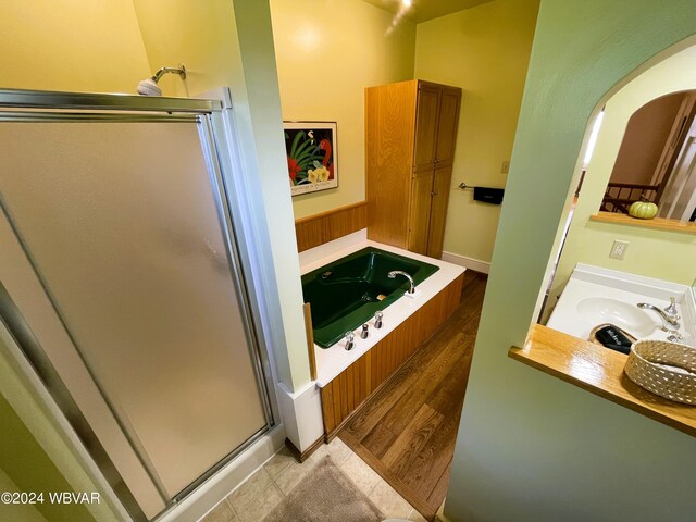 bathroom featuring separate shower and tub, sink, and wood-type flooring