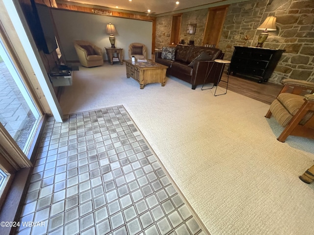 carpeted living room featuring a stone fireplace