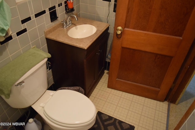 bathroom with vanity, toilet, decorative backsplash, and tile walls