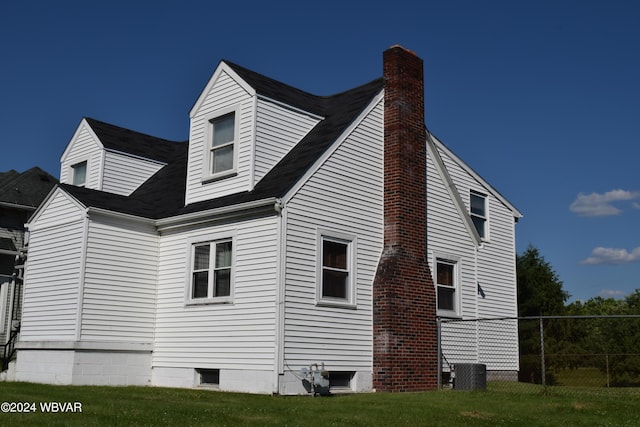 view of property exterior with a yard and central air condition unit