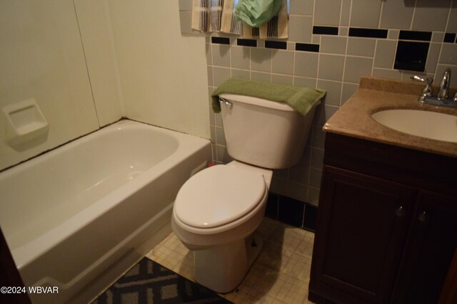 full bathroom with shower / bathing tub combination, vanity, toilet, and tile walls