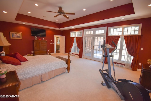 bedroom with light carpet, recessed lighting, and a raised ceiling