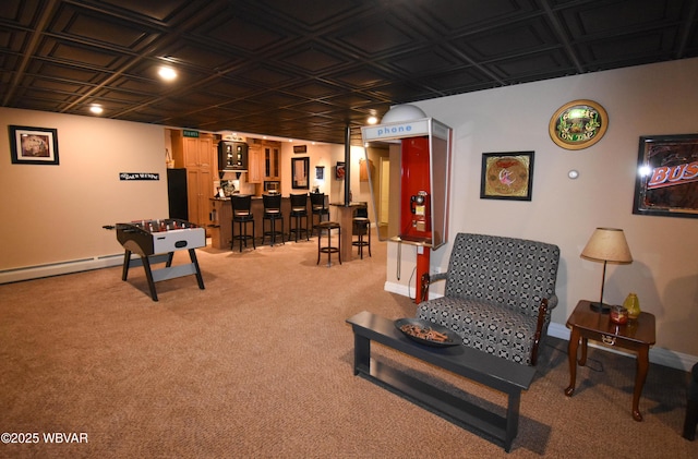 sitting room featuring indoor bar, an ornate ceiling, baseboards, and light colored carpet