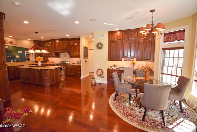 dining space with dark wood-style flooring, visible vents, an inviting chandelier, and recessed lighting