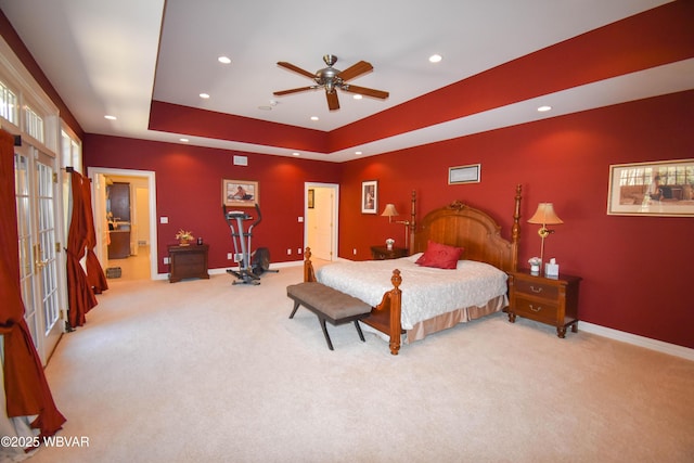 carpeted bedroom with a tray ceiling, baseboards, a wood stove, and recessed lighting