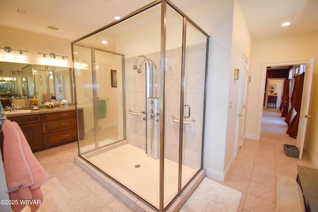 full bathroom featuring a stall shower, tile patterned floors, vanity, baseboards, and recessed lighting
