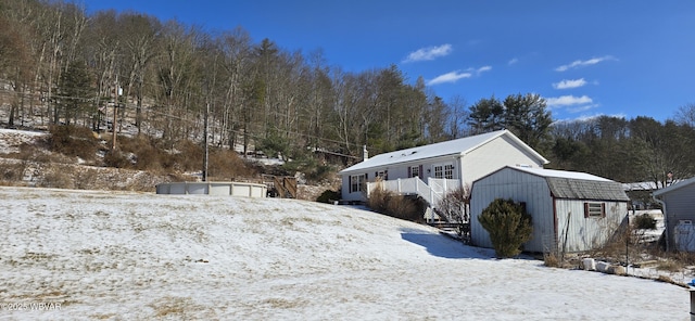 yard covered in snow featuring a storage shed